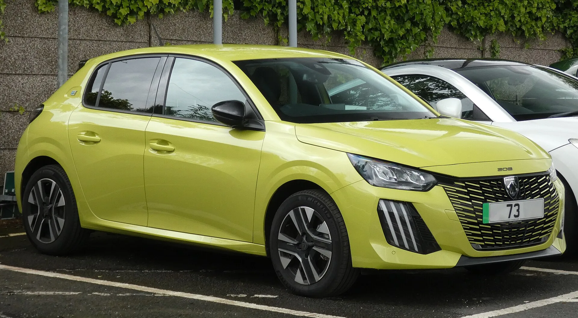 Peugeot e-208 amarelo — frente (fotografia de referência)